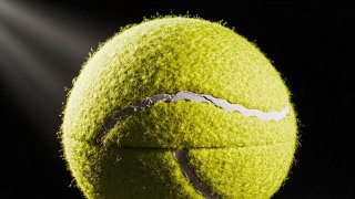 Uma bola de ténis hiper-realista encontra-se contra um fundo preto