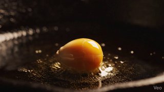 Close-up of a golden popcorn kernel in a pan with a small amount of
