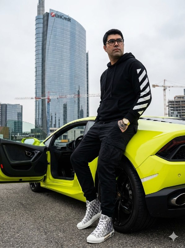 Person casually sitting on the rear-right fender of a vibrant neon
